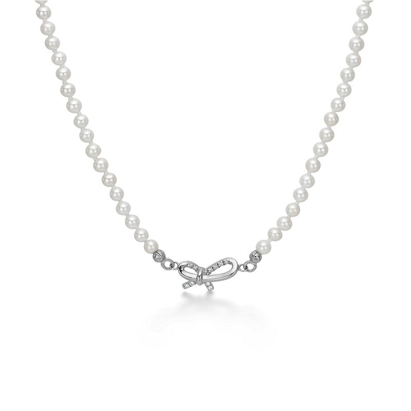 Miss Butterfly halskæde fra Mads Z i 925 sterlingsølv med hvide perler og sløjfe med topas.