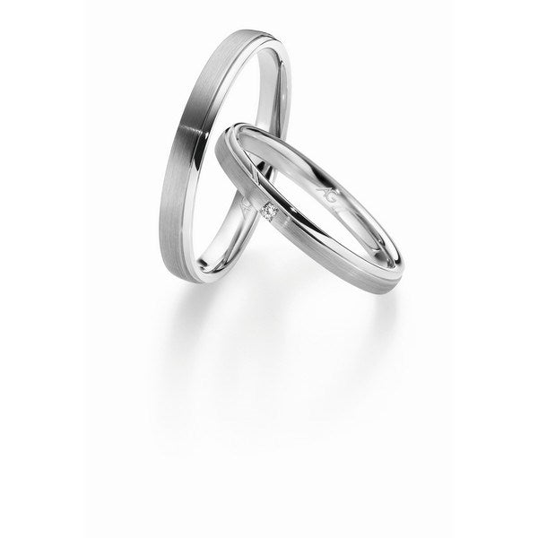 Luksuriøse Gerstner vielsesringe i 14 eller 9 karat hvidguld med silkemat overflade, blank yderkant og 0,015 ct diamant i dameringen.