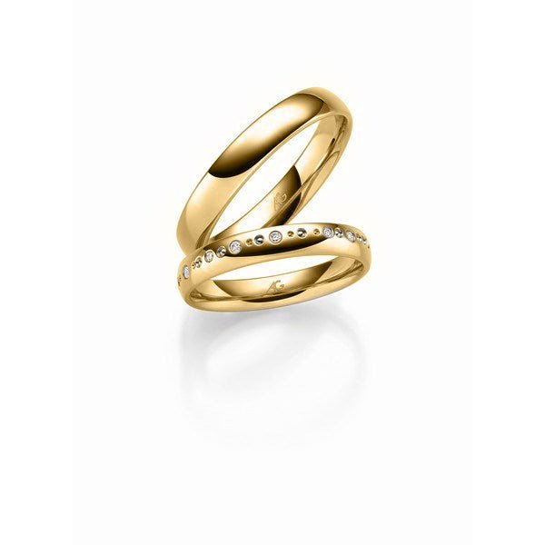 Eksklusivt Gerstner vielsesringsæt i 14 karat guld med blank overflade og 15 diamanter i asymmetrisk mønster.