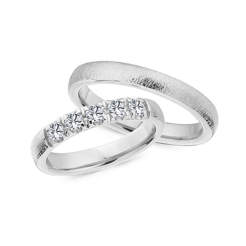 Eksklusive Nuran vielsesringe i 14 karat hvidguld med hamret overflade og 0,45 ct diamanter – sæt med herre- og damerring.