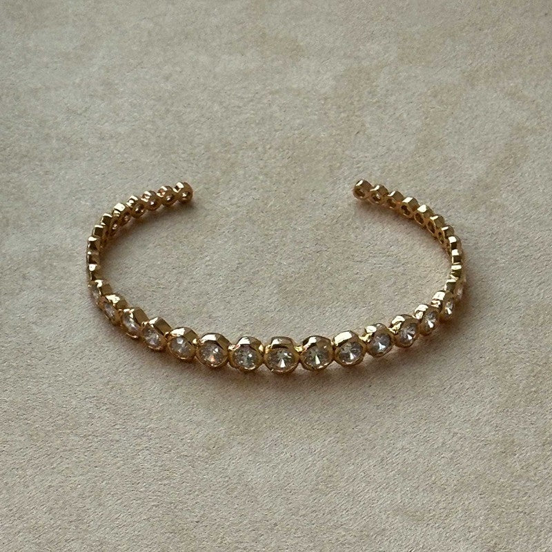 Elva krystalarmring fra Pico Copenhagen i forgyldt messing med klare krystaller i gradueret størrelse – onesize.