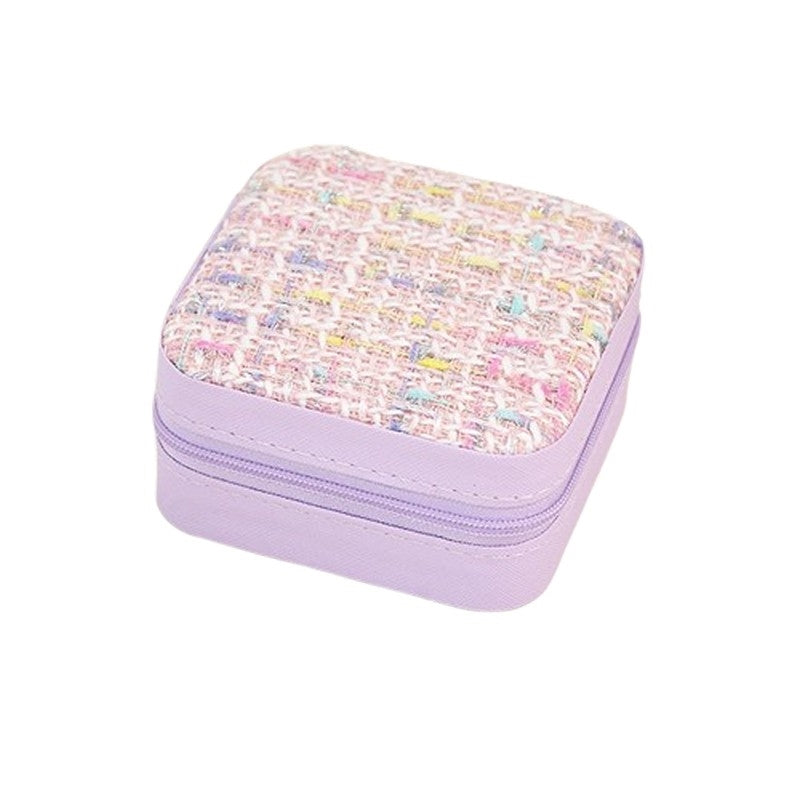 Smykkeskrin i lavendel bouclé fra Smykkecenter – kompakt opbevaring med tern i pastelfarver.