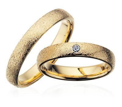 Scrouples vielsesringe i guld med rustik overflade og diamant – set fra oven