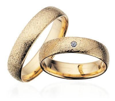 Scrouples vielsesring i guld med rustik overflade og diamant – nærbillede af fatning
