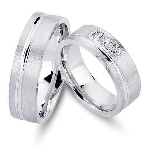 Smukke Nuran vielsesringe i rhodineret sølv med 3 klare zirkonia i damering – klassisk og tidløst design.