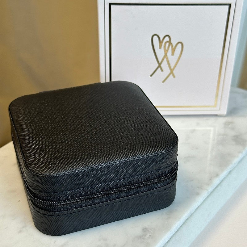 Sort smykkeskrin fra Guldcenter i slidstærkt syntetisk materiale med lynlåslukning, 10 x 10 cm.