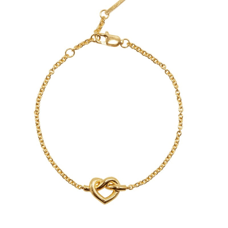 Jane Kønig Tied Heart armbånd i forgyldt sterlingsølv med flettet hjerte og justérbar længde 16–18 cm.