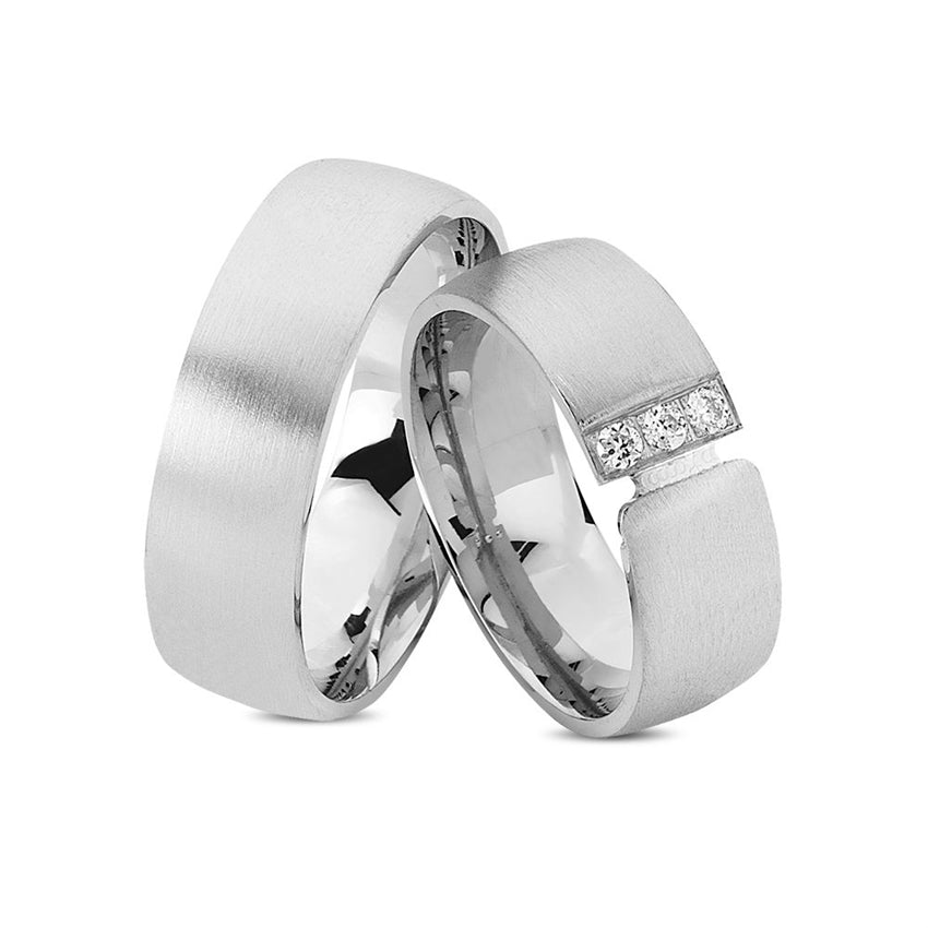 Unikke Nuran vielsesringe i rhodineret sølv med 3 klare zirkonia – 7 mm brede.